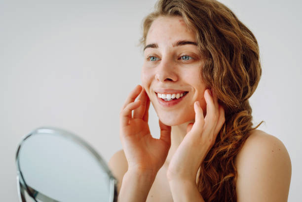 istock Beautiful woman with problematic skin looks in her small mirror. 1637600982