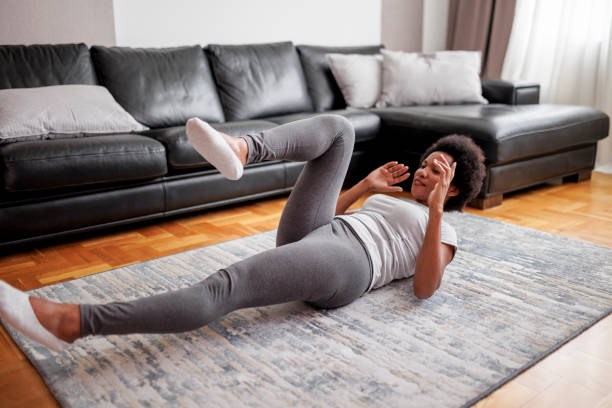 istock Athlete exercising sit-ups with hands behind her head at home 1637607399