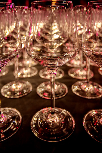 Empty glass transparent wine glasses on a table ready to serve.