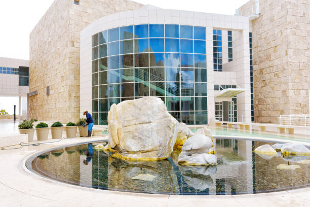 Los Angeles, California – January 5, 2023: Gardener Tending to Flowers Near Getty Center Fountain