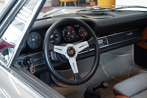 Vilnius, Lithuania - April 11, 2023: 1969 Porsche 911T, surrounded by other vintage cars in a private collection. Car after full restoration, painted in elegant grey colour. Stylish interior with Nardi steering wheel.
