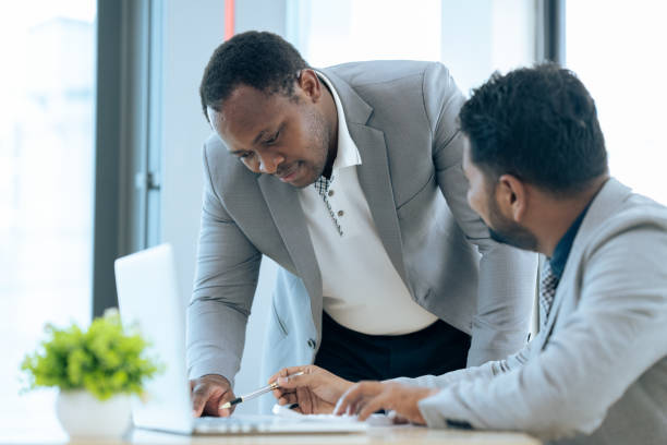istock Two happy diverse coworker discussing online presentation on laptop, working on project together 1637683806