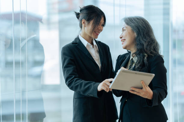 istock Two happy diverse coworker discussing report financial on tablet, working on project together 1637684159