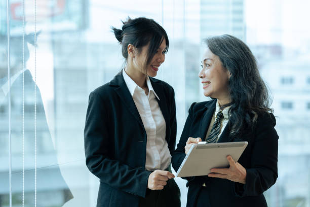 istock Two happy diverse coworker discussing report financial on tablet, working on project together 1637684352