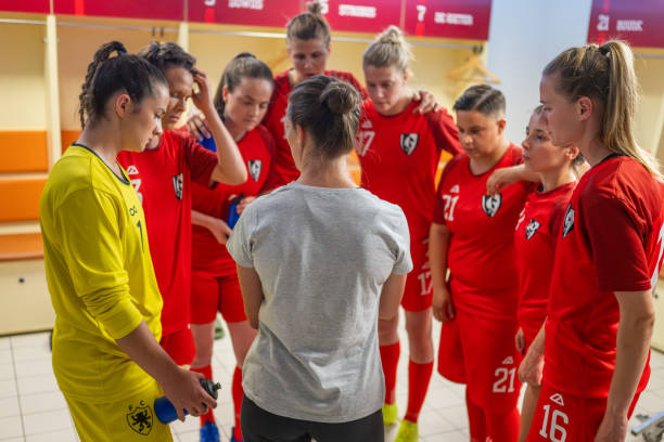 istock Coach instructing female football players 1637717290