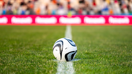 young girl kicking soccer ball on field