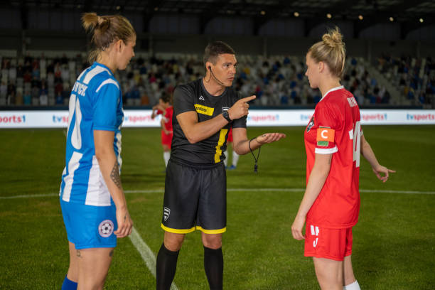 istock Referee with team captions on football pitch 1637717331