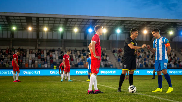 istock Referee with team captions on football pitch 1637717365