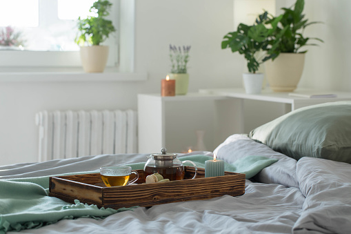 tea on wooden tray on bed at home