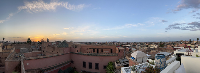 Morocco, Africa: panoramic view at sunset from a high rooftop, skyline of Marrakech, one of the four Imperial cities of Morocco situated west of the foothills of the Atlas Mountains