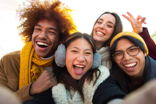 istock Happy multi-ethnic friends having fun outdoors. Multiracial young group of people taking selfie looking at camera. 1637743799