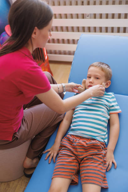 istock Female doctor using sensory cushions to stimulate perception in boy patient 1637752994