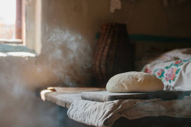 istock Raw loaf of bread on a wooden table. 1637766447