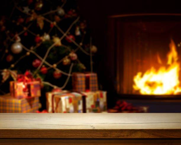 istock Empty wooden table over defocused Christmas background with Christmas tree, Gifts and fireplace; free space for your decoration. 1637767565