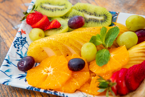 Close-up on tropical and continental fruit sliced and offered on tray in fine dining