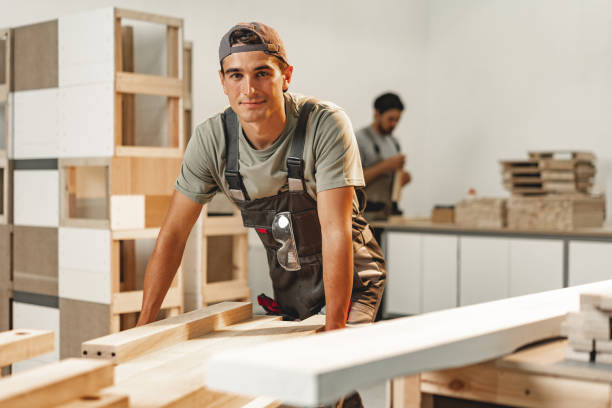Portrait of young male carpenter standing in the wood workshop stock photo