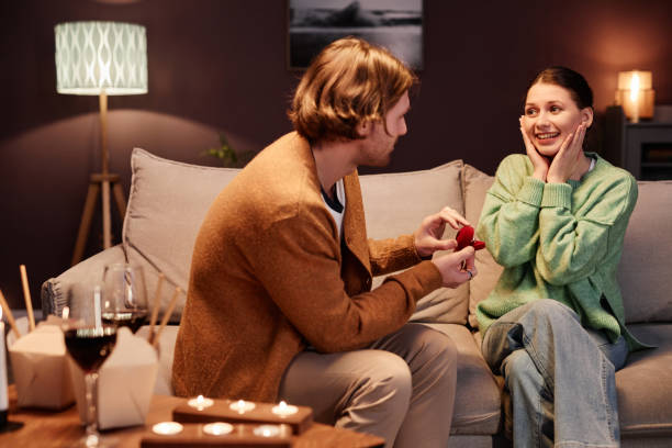 istock Young man proposing to girlfriend at home 1637842584