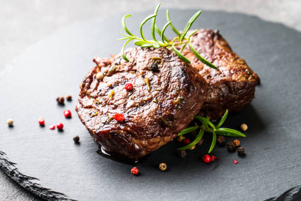 istock Beef medallions with spices and herbs at stone board. 1637845809