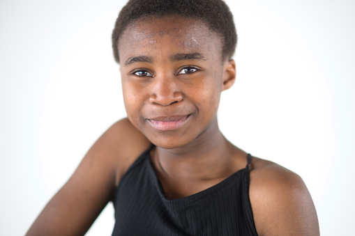 Shy and slightly smiling young Black Girl Studio Headshot