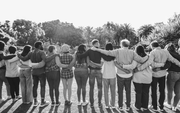 istock Group of multigenerational people hugging each others - Support, multiracial and diversity concept - Main focus on center people - Black and white editing 1637866060