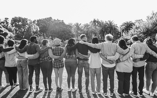 Group of multigenerational people hugging each others - Support, multiracial and diversity concept - Main focus on center people - Black and white editing