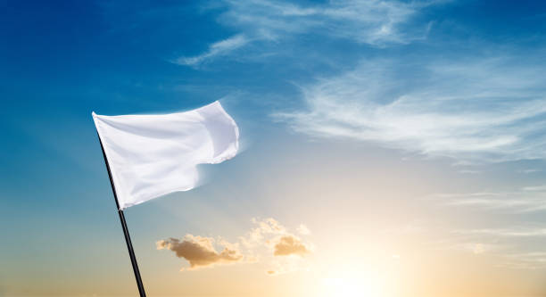 istock White flag flying against sunset sky background 1637872923