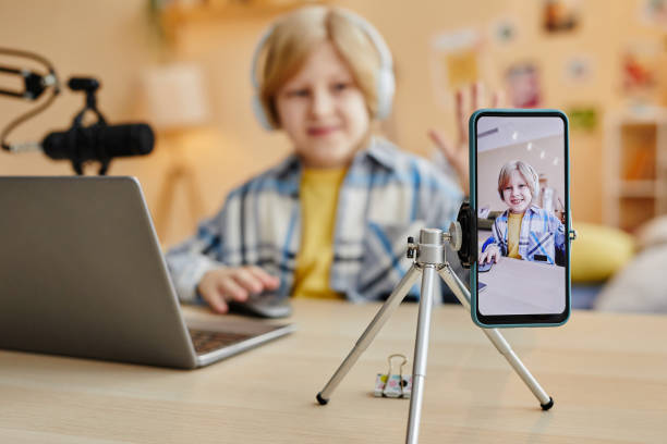istock Focus on smartphone screen with cute schoolboy clicking mouse 1637874004