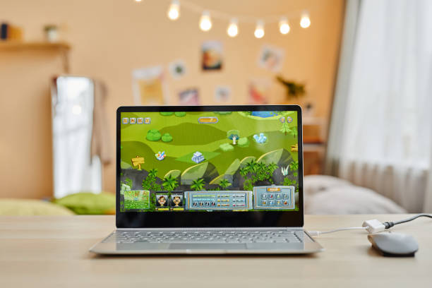 istock Laptop with video game on screen standing on desk in front of camera 1637874053