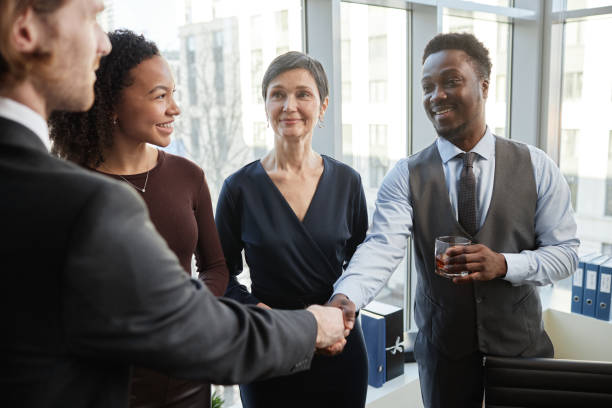 istock Diverse group of smiling business partners shaking hands in office 1637889718