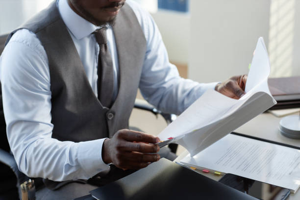 istock Professional black businessman reading documents at desk in office 1637889719