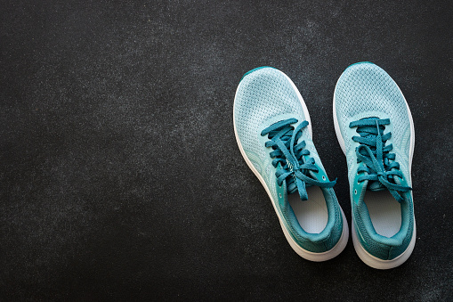 Sneakers at black background top view. Sport shoes.