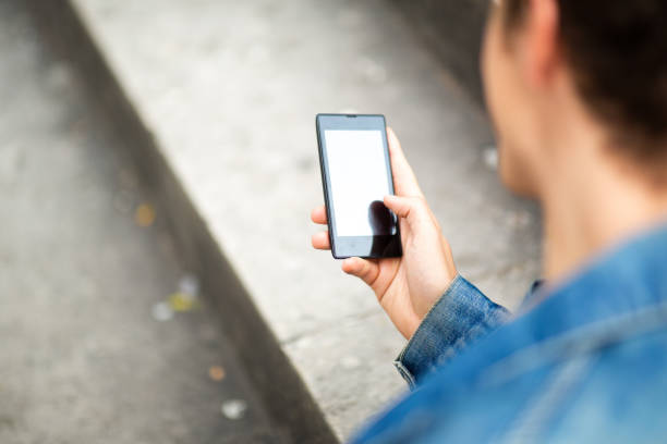 istock Man sitting outside and looking at mobile phone display 1637959505