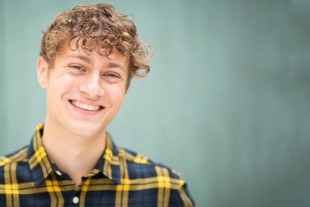 istock Happy young man smiling against green background 1637960637