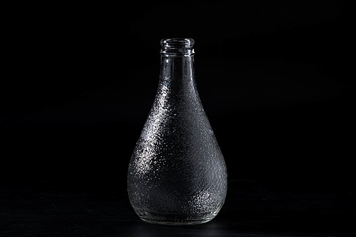 Empty glass bottle isolated on black background.