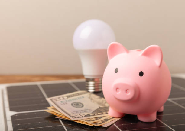 istock Flat lay composition with solar panel, LED lamp, piggy bank, house model and money on  texture background. Save money and clean energy concept. Ecology and sustainable development concept. 1637993500