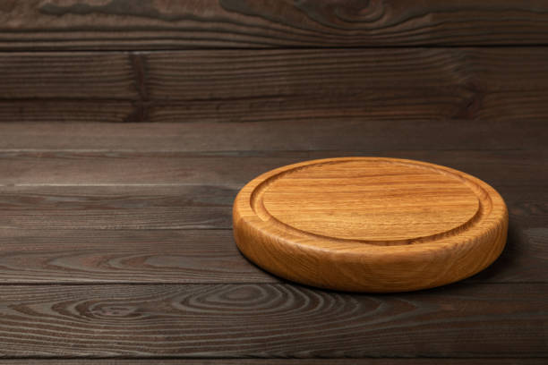 istock Cutting board over towel on wooden kitchen table. Cutting board and kitchen towel on brown textured background. Menu food card or recipes background concept.MOCKUP. Design. Place for text, copy space. 1638002599