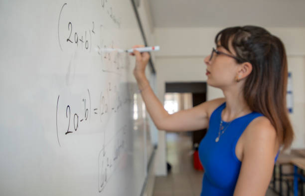 istock A teacher at school teaches by writing on a white erasable blackboard 1638014836