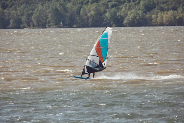 Windsurfer riding waves and jumping