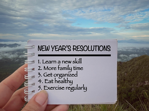 New Year's Resolutions and lists written on notepad. With blurred styled background.