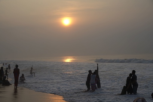 Puri, India – September 25, 2022: Sept 25, 2022, Puri, Odisha, India-Tourists enjoying at sea beach during sunrise at Sargodwar, Puri, Odisha