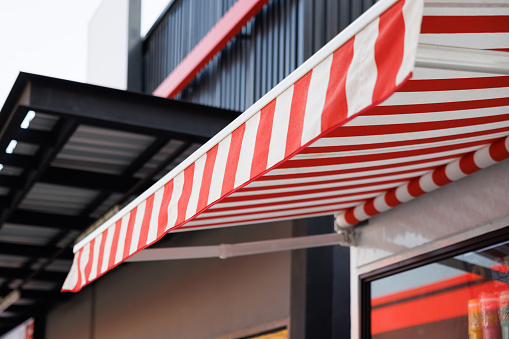 red and white striped awning. canvas roof of shop.