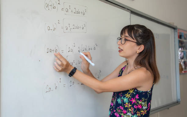 istock A teacher at school teaches by writing on a white erasable blackboard 1638048208