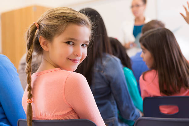 istock Cute girl looking back during parent school meeting 163805634