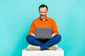Full size body photo of satisfied mature age business worker leader man sit lounge zone browsing netbook isolated on blue color background