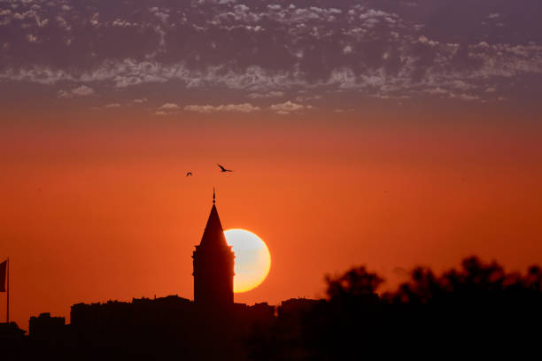 sun setting down in istanbul silhouette, showing Galata Tower and a huge Turkish Flag