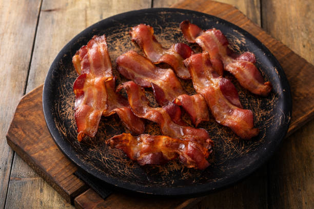 istock Cooked bacon on a wooden serving plate 1638099194