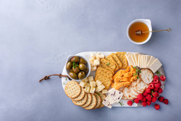 istock Cheese board or snack board with crackers, cheese, olives and berries 1638115493