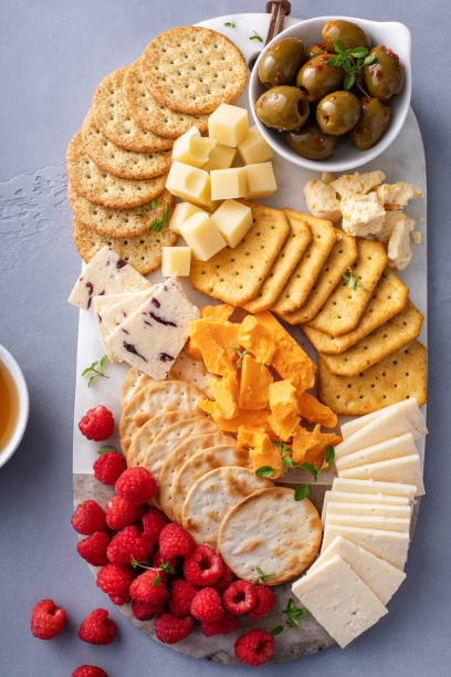 istock Cheese board or snack board with crackers, cheese, olives and berries 1638115500