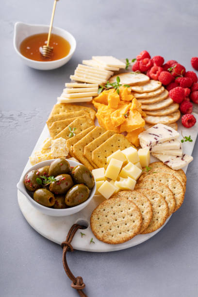 istock Cheese board or snack board with crackers, cheese, olives and berries 1638115508