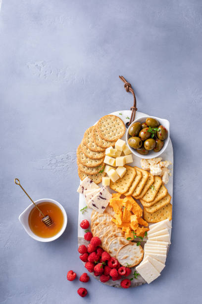 istock Cheese board or snack board with crackers, cheese, olives and berries 1638115525